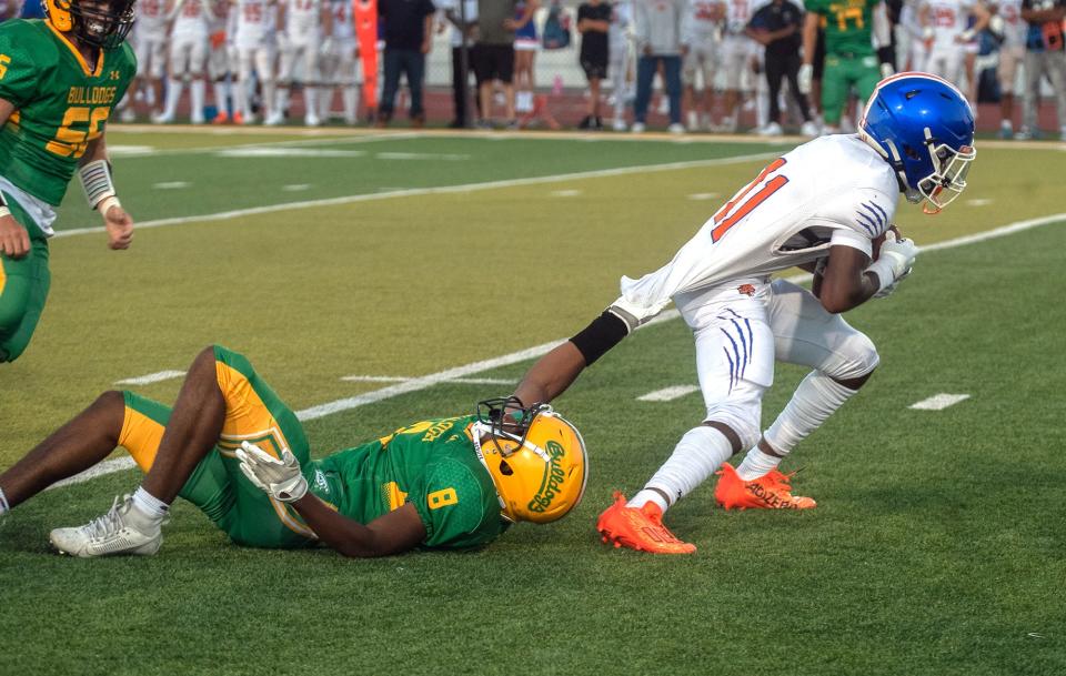 Tracy's Jeremy Haynes, left makes a shirttail tackle on Kimball's Darius Doyle during a varsity football game at Tracy's Wayne Schneider Stadium in Tracy.