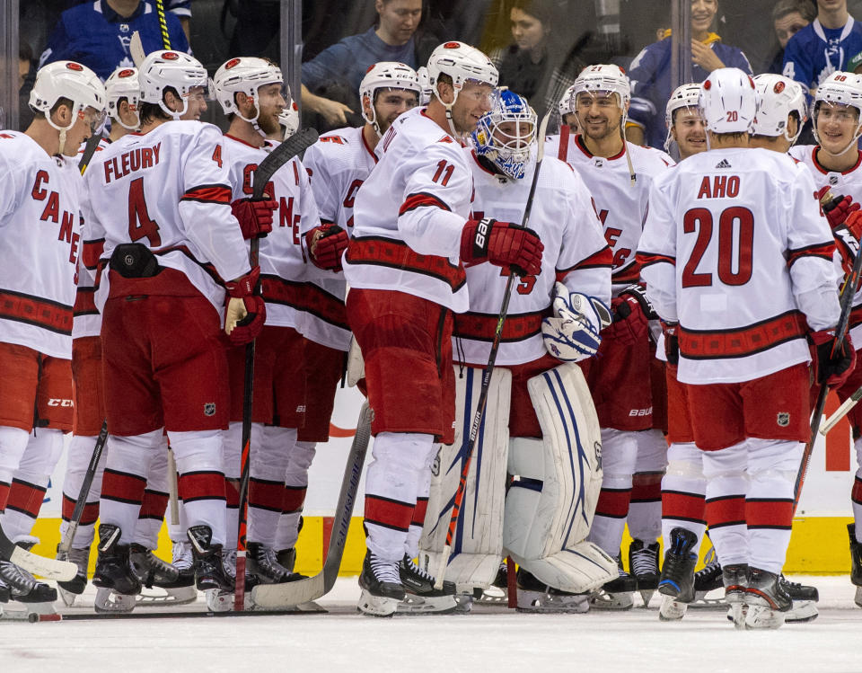 In this Saturday, Feb. 22, 2020 photo, members of the Carolina Hurricanes congratulate emergency goaltender David Ayres after they beat the Toronto Maple Leafs 6-3 in an NHL hockey game in Toronto, Saturday, Feb. 22, 2020. (Frank Gunn/The Canadian Press via AP)