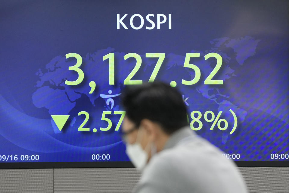A currency trader talks near the screen showing the Korea Composite Stock Price Index (KOSPI) at a foreign exchange dealing room in Seoul, South Korea, Friday, Sept. 17, 2021. Asian shares were mixed on Friday after a hodge-podge of economic data led Wall Street to close mostly lower. (AP Photo/Lee Jin-man)