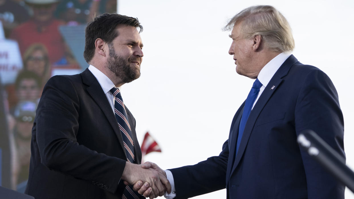 J.D. Vance shakes hands with former President Donald Trump. 