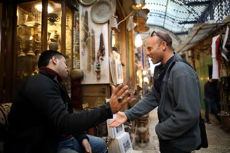Eitan Klein, deputy director of the Israel Antiquities Authority's robbery prevention unit, greets a man near shops selling antiques at a market in Jerusalem's Old City November 25, 2018. Picture taken November 25, 2018. REUTERS/Corinna Kern