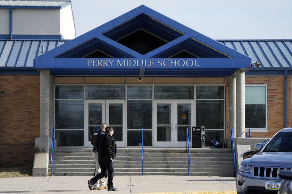 Law enforcement officials walks past the Perry Middle School entrance following a shooting at the nearby Perry High School, Thursday, Jan. 4, 2024, in Perry, Iowa. Multiple people were shot inside the school early Thursday as students prepared to start their first day of classes after their annual winter break, authorities said. (AP Photo/Charlie Neibergall)