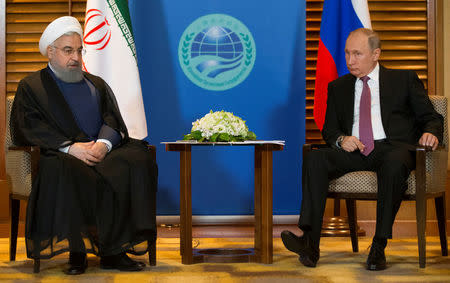 Russian President Vladimir Putin (R) meets with Iranian President Hassan Rouhani on the sidelines of the Shanghai Cooperation Organisation Summit (SCO) in Qingdao, China June 9, 2018. Alexander Zemlianichenko/Pool via REUTERS
