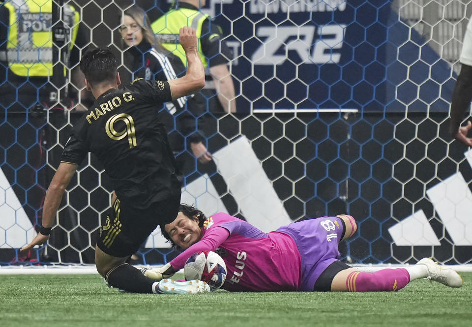 Vancouver Whitecaps goalkeeper Yohei Takaoka, bottom right, stops Los Angeles FC's Mario Gonzalez (9) during the first half in Game 2 of a first-round MLS playoff soccer match in Vancouver, British Columbia, Sunday, Nov. 5, 2023. (Darryl Dyck/The Canadian Press via AP)