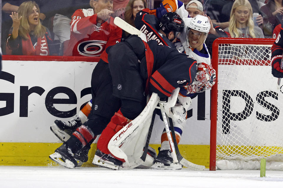 Carolina Hurricanes' Tony DeAngelo (77) and goaltender Frederik Andersen (31) tangle with New York Islanders' Anders Lee (27) during the second period in Game 5 of an NHL hockey Stanley Cup first-round playoff series in Raleigh, N.C., Tuesday, April 30, 2024. (AP Photo/Karl B DeBlaker)