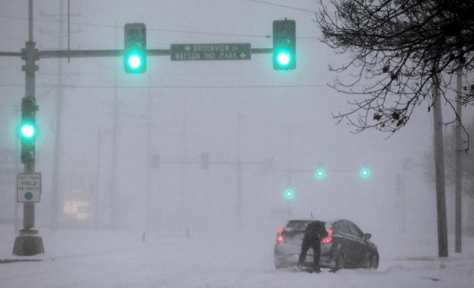 A Crestwood motorist tries to get his car moving along Watson Road in St. Louis as heavy snow falls on Sunday, Jan. 5, 2014. Snow-covered roads, high winds and ice were creating dangerous driving conditions from Missouri to Delaware on Sunday ahead of a "polar vortex" that'll bring below-zero temperatures not seen in years to much of the nation in the coming days, likely setting records. (AP Photo/St. Louis Post-Dispatch, Robert Cohen) EDWARDSVILLE INTELLIGENCER OUT; THE ALTON TELEGRAPH OUT