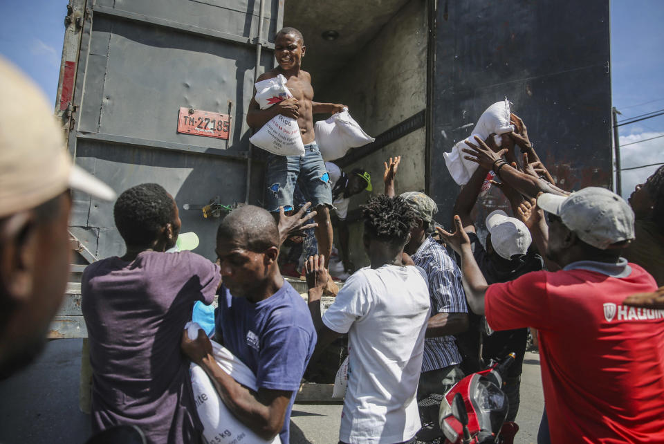 Rice is distributed to residents in Les Cayes, Haiti, Monday, Aug. 16, 2021, two days after a 7.2-magnitude earthquake struck the southwestern part of the hemisphere's poorest nation on Aug. 14. (AP Photo/Joseph Odelyn)