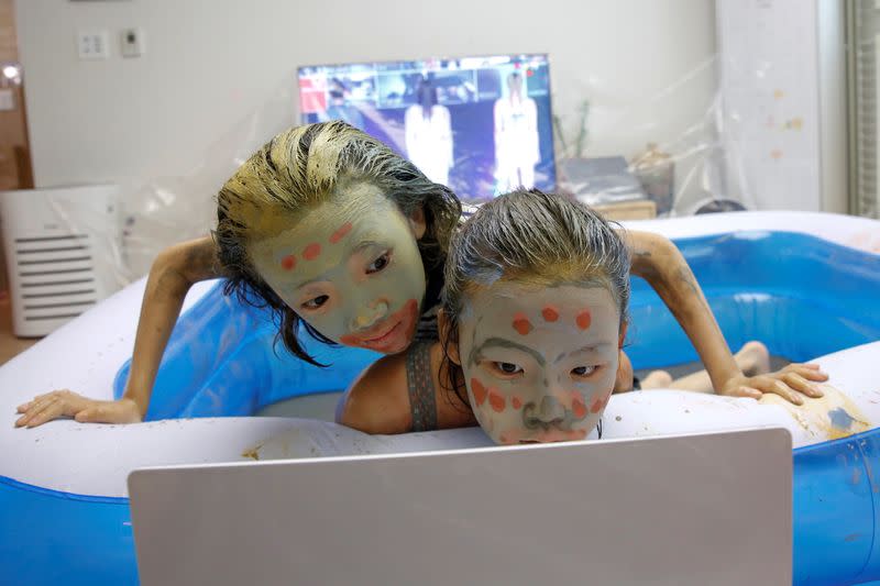 Children play in a mud pool during the Online Boryeong Mud Festival at their home during a live streaming event, in Gwangju