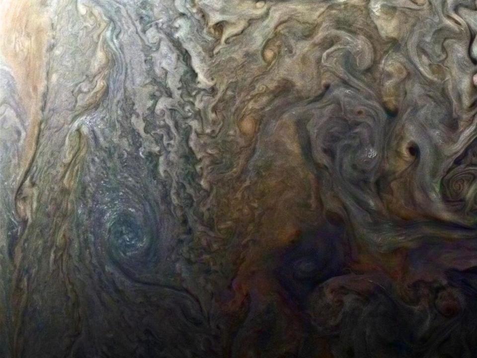 Nasa's enhanced-colour image of a mysterious dark spot on Jupiter shows a Jovian 'galaxy' of swirling storms (Reuters)