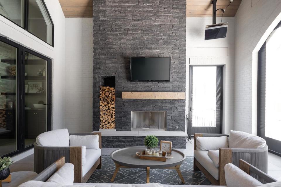 A statement fireplace is clad in dark stone