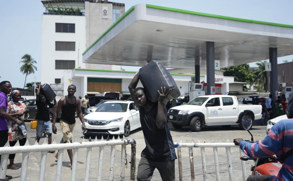 A man carries fuel from a petrol station in Lagos, Nigeria Tuesday, April 30, 2024. Nigerians were queuing for hours to buy fuel across major cities on Tuesday as the West African nation faced its latest fuel shortage, resulting in increased hardship for millions already struggling with the country's economic crisis. (AP Photo/Sunday Alamba)