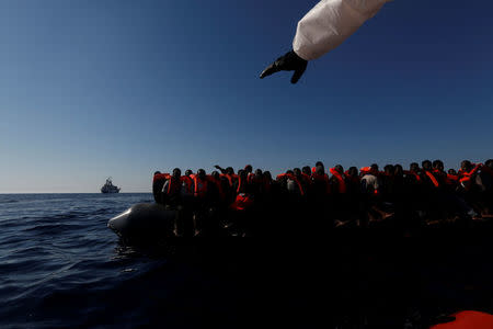 Migrants on a rubber dinghy await rescue by the Malta-based NGO Migrant Offshore Aid Station (MOAS) in the central Mediterranean in international waters some 15 nautical miles off the coast of Zawiya in Libya, April 14, 2017. REUTERS/Darrin Zammit Lupi