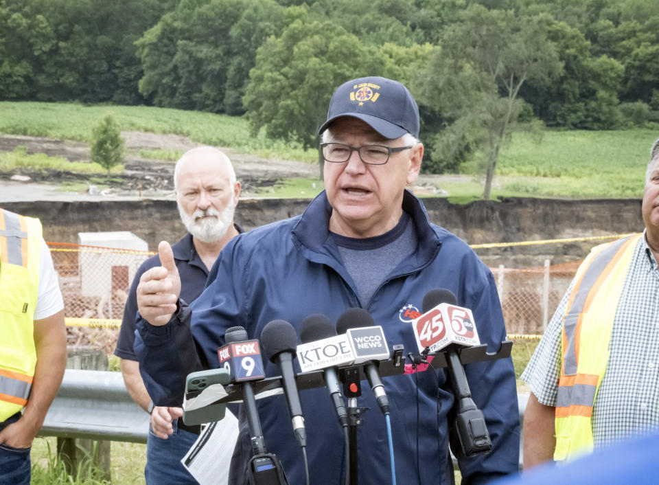 Minnesota Gov. Tim Walz addresses media members Tuesday, July 2, 2024, at the Rapidan Dam, in Rapidan, Minn. Rushing waters from the Blue Earth River have already left a trail of debris and destruction on the edges of a southern Minnesota dam that partially failed last week. (Casey Ek/The Free Press via AP)