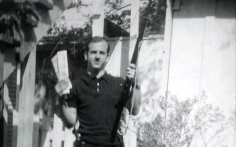 Lee Harvey Oswald, accused of assassinating former U.S. President John F. Kennedy, is pictured holding a rifle and communist flag in this undated Dallas Police Department Archive image - Credit: Reuters