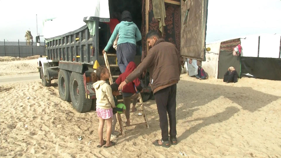 Palestinian Mariam Abu Eida leads members of her family into the truck they're using as a shelter in the demilitarized zone known as the Philadelphi Corridor along the southern Gaza border with Egypt, Jan. 17, 2024. / Credit: CBS News
