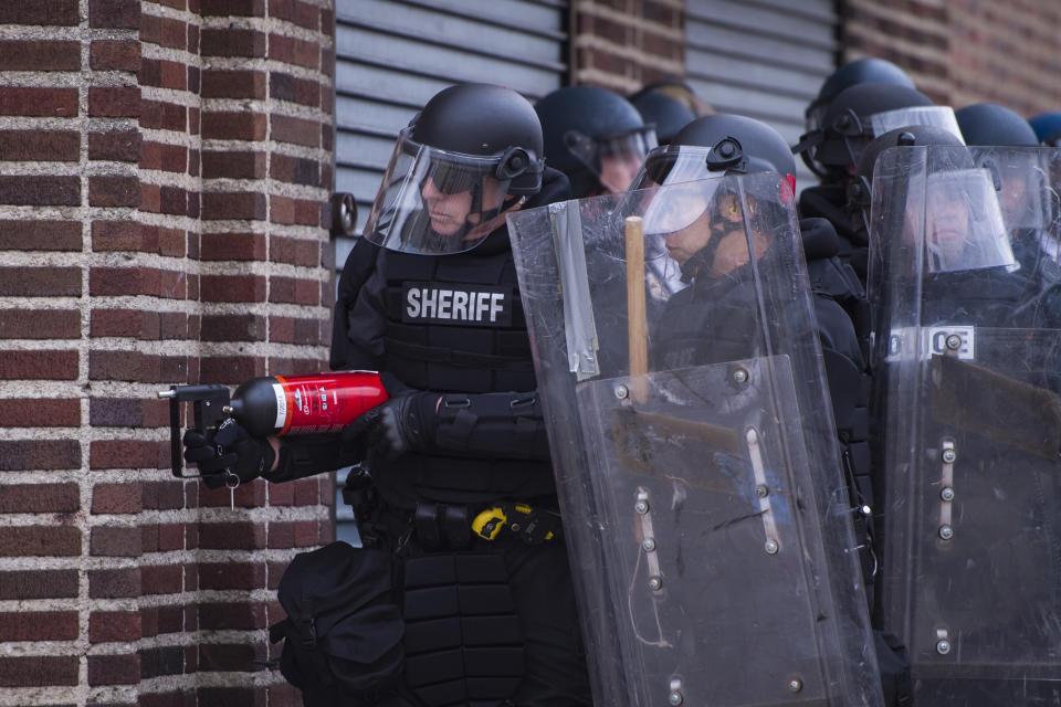 BALTIMORE, MD - APRIL 27: Officers look for people throwing objects at them near West North Avenue and Pennsylvania Avenue during a protest for Freddie Gray in Baltimore, MD on Monday April 27, 2015. Gray died from spinal injuries about a week after he was arrested and transported in a police van. (Photo by Jabin Botsford/The Washington Post via Getty Images)