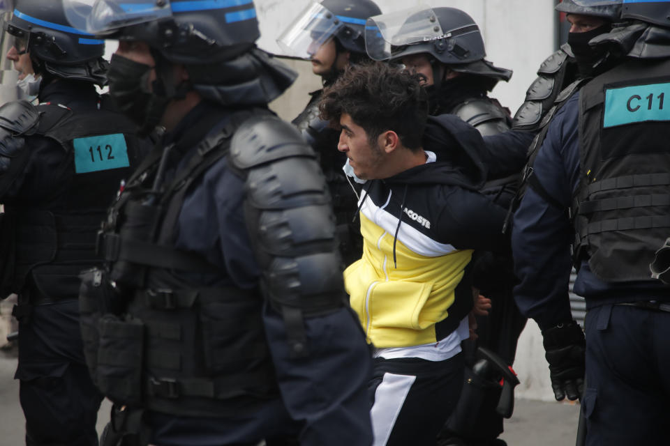 A demonstrator is detained by riot police officers during a banned protest in support of Palestinians in the Gaza Strip, Saturday, May, 15, 2021 in Paris. Marches in support of Palestinians in the Gaza Strip were being held Saturday in a dozen French cities, but the focus was on Paris, where riot police got ready as organizers said they would defy a ban on the protest. (AP Photo/Michel Euler)