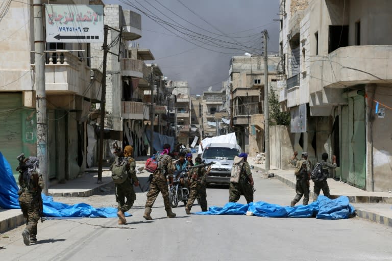 Members of the Syrian Democratic Forces (SDF) patrol a street in the northern town of Manbij on August 7, 2016, as they comb the city in search of the last remaining jihadists