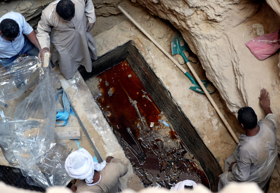 Workers&nbsp;open a coffin containing skeletal remains&nbsp;lying in sewage water in Alexandria, Egypt, on Thursday. (Photo: Mohamed Abd El Ghany / Reuters)