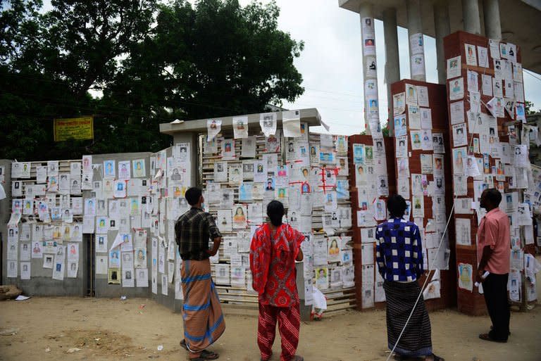 Relatives look at a board posting notices of missing and dead workers of an eight-storey building collapse in Savar on the outskirts of the Bangladeshi capital Dhaka on May 4, 2013. The death toll from Bangladesh's worst industrial disaster surpassed 600 Sunday after dozens of bodies were pulled from the wreckage of a nine-storey building housing garment factories, the army said