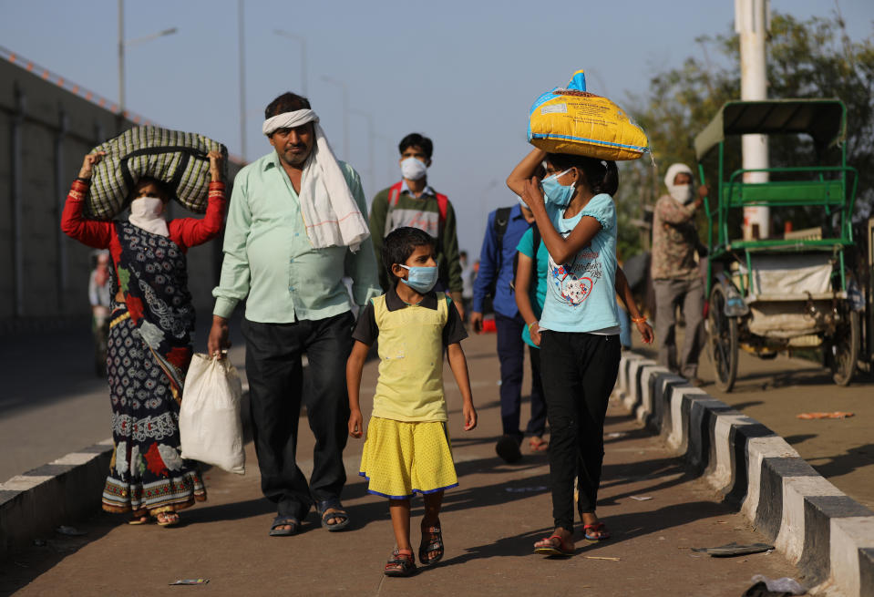 NEW DELHI, INDIA - MARCH 28: Migrant workers along with their family members walk to their villages amid the nationwide lockdown, in wake of coronavirus (COVÄ°D-19) pandemic, at Delhi Uttar Pradesh Border, in New Delhi on March 28, 2020. (Photo by Amarjeet Kumar Singh/Anadolu Agency via Getty Images)