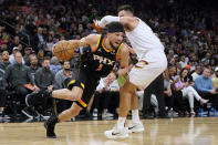 Phoenix Suns guard Devin Booker (1) drives to the basket against Cleveland Cavaliers guard Max Strus during the first half of an NBA basketball game in Phoenix, Wednesday, April. 3, 2024. (AP Photo/Darryl Webb)