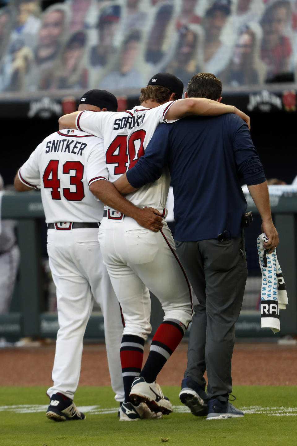 Atlanta Braves starting pitcher Mike Soroka (40) is helped off the field by manager Brian Snitker (43) and a trainer after being injured in the third inning of a baseball game against the New York Mets Monday, Aug. 3, 2020, in Atlanta. (AP Photo/John Bazemore)
