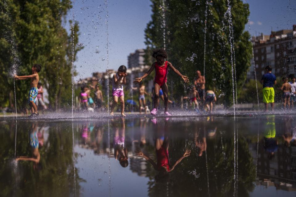 FILE - Children cool off at an urban beach at Madrid Rio park in Madrid, Spain, June 26, 2023. The National Oceanic and Atmospheric Administration said Thursday, July 13, an already warming Earth steamed to its hottest June on record. (AP Photo/Manu Fernandez, Fie)