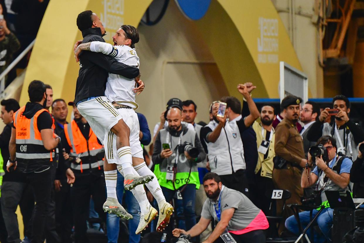 Real Madrid's Sergio Ramos (right) celebrates with teammate Eder Militao after winning the Spanish Super Cup on Sunday in Saudi Arabia. (Photo by GIUSEPPE CACACE/AFP via Getty Images)