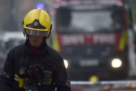 A firefighter walks near a fire at a low-rise block of buildings in Bethnal Green, northeast London, Britain, June 24, 2017. REUTERS/Hannah McKay