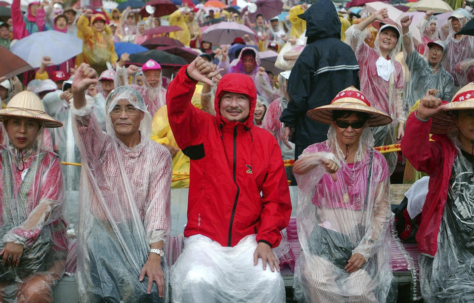 FILE - Sitting with hundreds of other protesters, veteran Taiwanese human rights activist Shih Ming-teh, center, gives a "thumbs down" to Taiwan's President Chen Shui-bian during the fourth day of a sit-in aimed to oust Chen in front of the Presidential Office in Taipei, Taiwan, on Sept. 12, 2006. Shih, a democracy activist who helped lead Taiwan from authoritarianism to democracy and a former chairman of the ruling Democratic Progressive Party, died Monday, Jan. 15, 2024, at the age of 83, his family said. (AP Photo/Chiang Ying-ying, File)