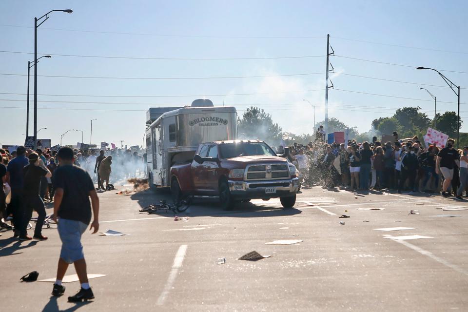 A pickup drives through a group of protesters who shut down Interstate 244 during a rally May 31 in Tulsa, Okla. The march was to mark the anniversary of the Tulsa race massacre in 1921 and to protest the death of George Floyd, who was pinned at the neck by a Minneapolis police officer.