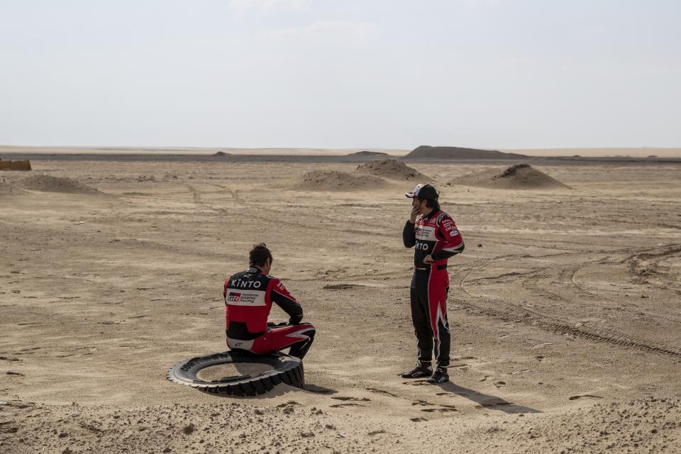 El piloto español Fernando Alonso (derecha) y su copiloto español Marc Coma tras el final de la décima etapa del Rally Dakar entre Haradth y Shubaytah, Arabia Saudita, el miércoles 15 de enero de 2020. (AP Foto/Bernat Armangue)