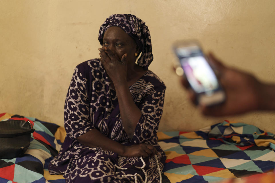 Seynabou Diop reacts as she sits next to her husband while he holds a mobile phone with a picture of their son, Khadim Ba, 21, who died during the protests earlier this month in Dakar, Senegal, Thursday, June 15, 2023. "If I had known (he was going to protest), Khadim would never have taken part," said Diop. "I want (the government) to meet the expectations of young people, the government has an obligation to help (them)," she said. (AP Photo/Leo Correa)