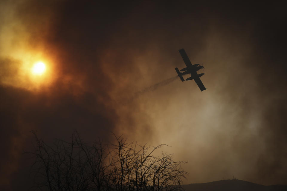 Un avión lanza agua sobre incendios en Córdoba, Argentina, el lunes 12 de octubre de 2020. (AP Foto/Nicolas Aguilera)