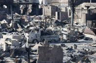 A view of burnt vehicles and ruins of houses gutted by a fire caused by fighting between government soldiers and Muslim rebels from the Moro National Liberation Front (MNLF) in Zamboanga city in southern Philippines September 13, 2013. According to local government officials, the number of evacuees reached about 20,000 people on the fifth day of a government stand-off with the MNLF seeking an independent state. REUTERS/Erik De Castro (PHILIPPINES - Tags: CIVIL UNREST SOCIETY POLITICS)