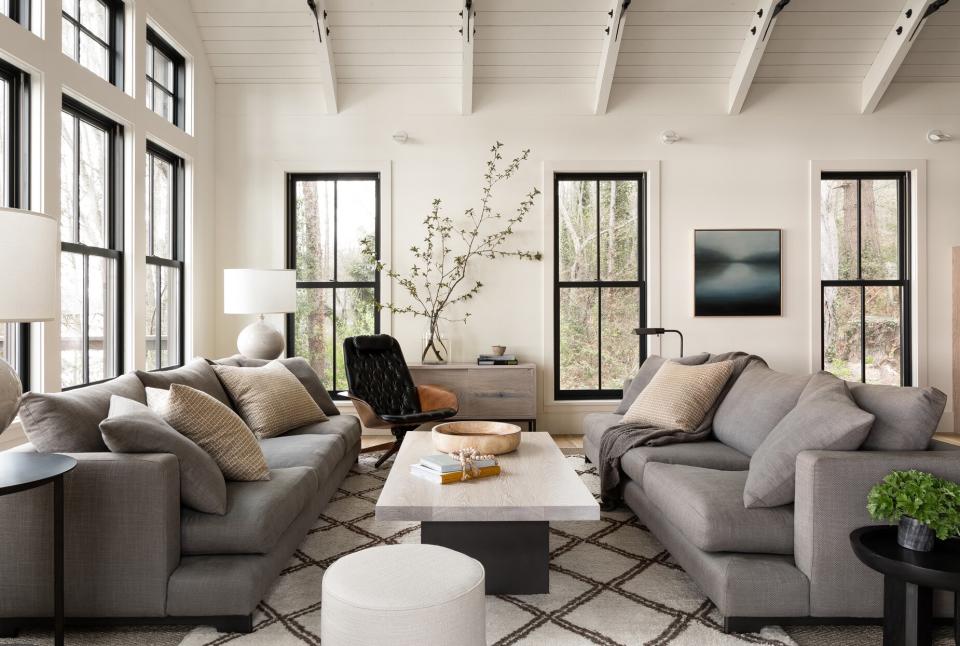 neutral-colored living room with greenery accents and vaulted ceiling