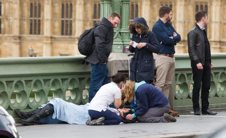 Medics and passers by tending to one of the victims on Westminster Bridge (REX/Shutterstock)