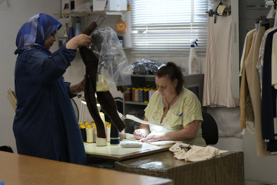 Workers check D.Exterior clothes at the Cose di Maglia factory, in Brescia, Italy, Tuesday, June 14, 2022. Small Italian fashion producers are still allowed to export to Russia, despite sanctions, as long as the wholesale price is under 300 euros. But they are having a hard time getting paid, due to restrictions tied to the financial sector. (AP Photo/Luca Bruno)