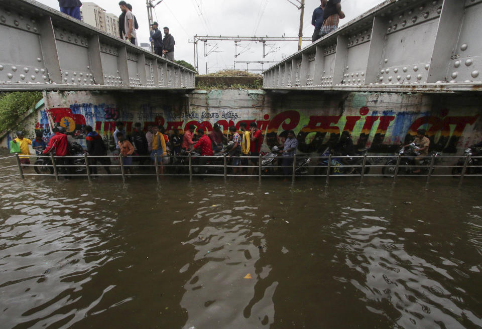 People make their way through a flooded underpass in Chennai, India, Wednesday, Nov.25, 2020. India’s southern state of Tamil Nadu is bracing for Cyclone Nivar that is expected to make landfall on Wednesday. The state authorities have issued an alert and asked people living in low-lying and flood-prone areas to move to safer places. (AP Photo/R. Parthibhan)