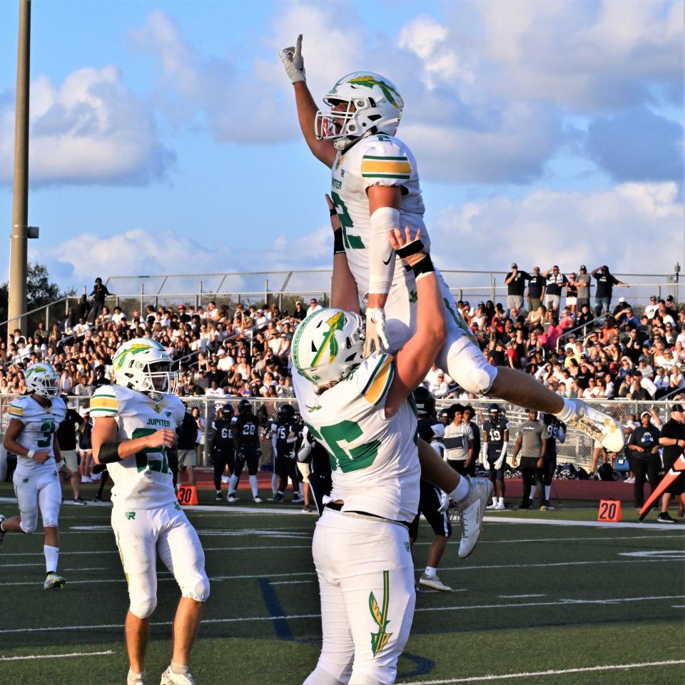 Jupiter's Preston Douglas celebrates with his teammates after scoring the Warriors' first touchdown of the season, helping Jupiter to a 24-10 victory over visiting Dwyer (Aug. 25, 2023).