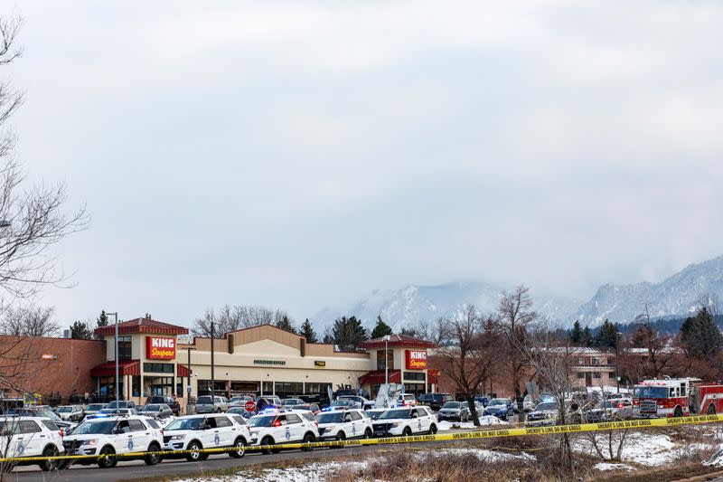 Law enforcement vehicles line up at the perimeter of a shooting site at a King Soopers grocery store in Boulder