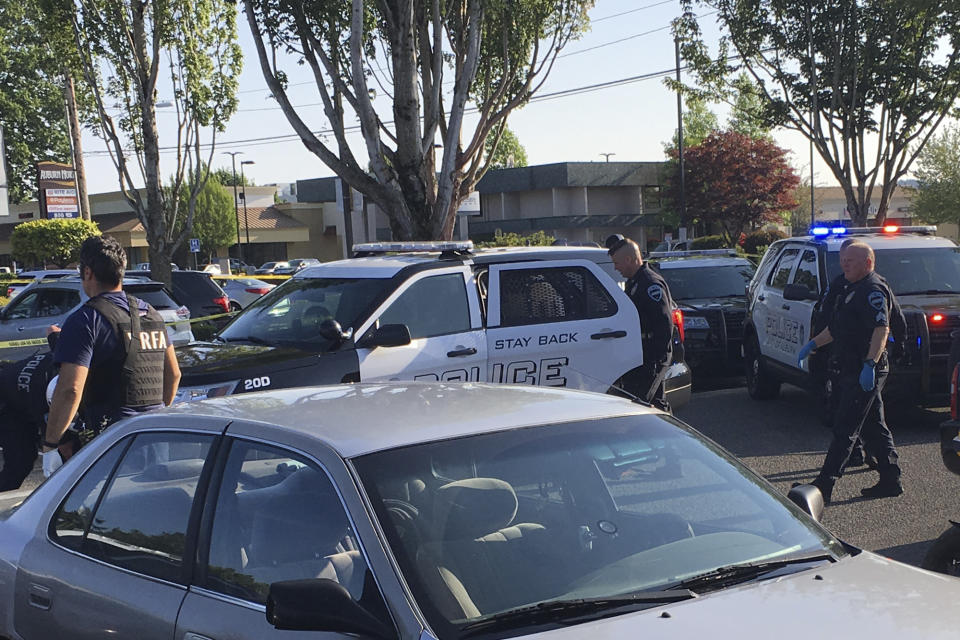 In this May 31, 2019, photo provided by the Auburn Police Department via the Port of Seattle Police Department, Auburn police Officer Jeff Nelson, second from right, is shown at the scene where he shot and killed Jesse Sarey in a grocery store parking lot in Auburn, Wash. Although Nelson has been investigated in more than 60 use-of-force cases since 2012, he wasn't placed on the King County Prosecuting Attorney's "potential impeachment disclosure" list, or Brady List, which flags officers whose credibility is in question due to misconduct, until after he was charged in Sarey's killing. (Auburn Police Department via Port of Seattle Police Department via AP)