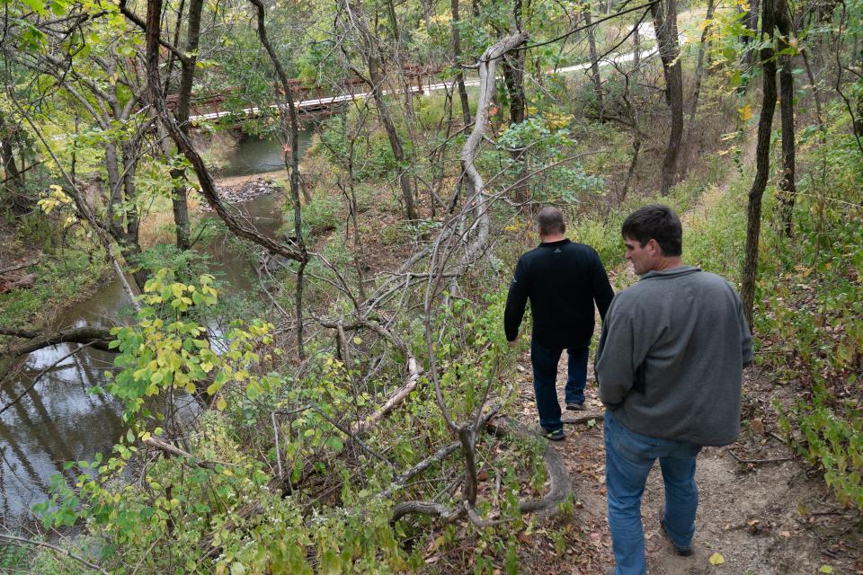 Shawnee County district trail managers Scott Terry, left, and Tom Hammer walk down a part of the blue trail at Dornwood Nature Trails that overlook Deer Creek.