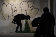 A visitor walks past "Better Out then In", a reproduction of a mural by British artist Banksy, during the unveiling of the "The World of Banksy, The Immersive Experience" exhibition, in Milan, Italy, Thursday, Dec. 2, 2021. An exhibition of 130 works by British street artist Banksy opens Friday in a gallery space inside Milan's Central train Station. The exhibition unveiled on Thursday includes 30 never before seen works by Bansky and highlights pieces by young unknown artists from all over Europe. (AP Photo/Luca Bruno)