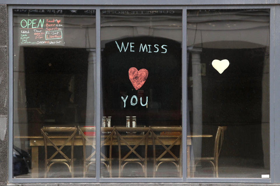 FILE - In this April 28, 2020, file photo, a message is posted on the front window of the Ranging Bull Saloon which remains closed during the coronavirus pandemic in Augusta, Maine. (AP Photo/Robert F. Bukaty, File)