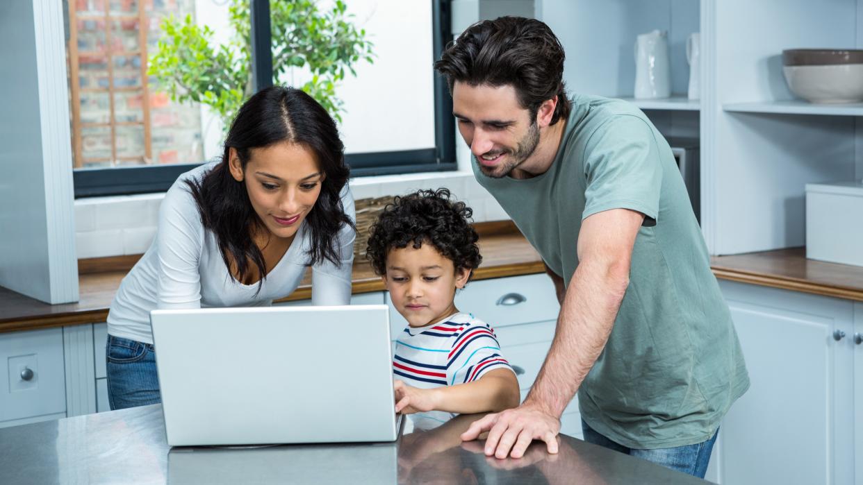  Parents with child, learning from a laptop at home. 