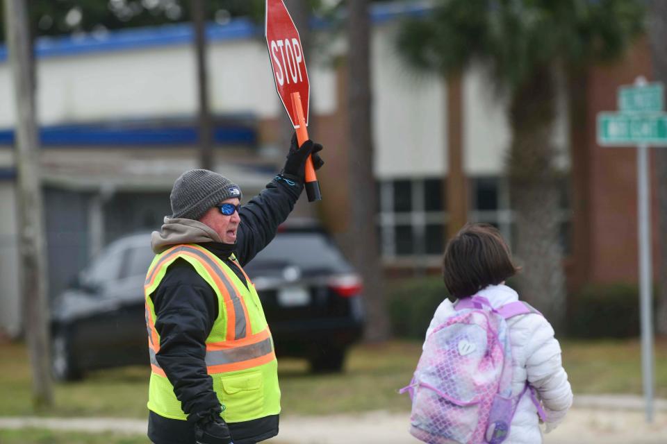 Crossing guard Jim Welch is bundled up against Friday's mid-30s temperatures as he helps students cross Hollwyood Boulevard to Edwins Elementary School.