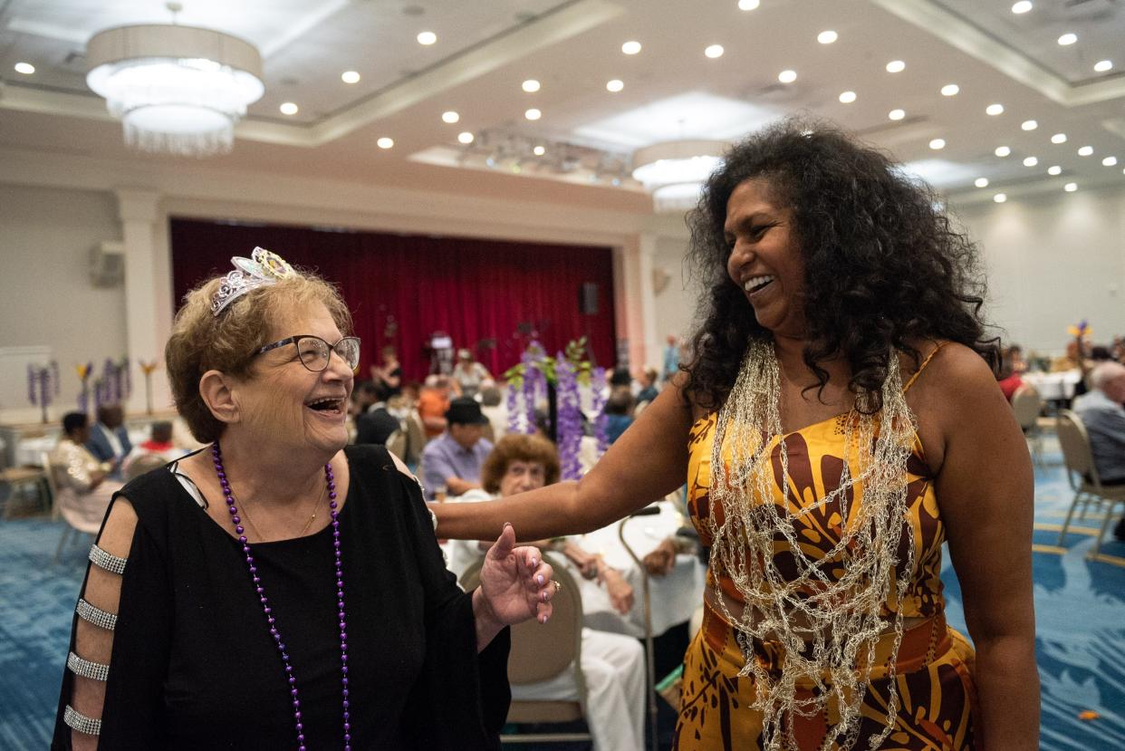 Sandy Rubin, left, president of Young at Heart - a social group for seniors - shares a humorous moment with Shakeera Thomas, supervisor of senior citizen programming for Royal Palm Beach, during a 'Young At Heart' prom for seniors held at the the Royal Palm Beach Cultural Center last May in Royal Palm Beach.