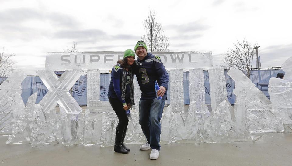 Seattle Seahawks fans Aaron Hulet, right, and Erica Hulet, pose for a picture in front of an ice sculpture before the NFL Super Bowl XLVIII football game between the Seattle Seahawks and the Denver Broncos Sunday, Feb. 2, 2014, in East Rutherford, N.J. (AP Photo/Matt York)